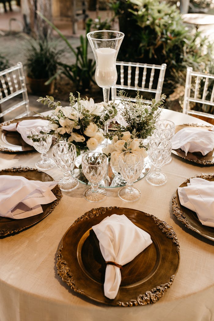 Elegant outdoor table setting with floral centerpiece and candle for special occasion.